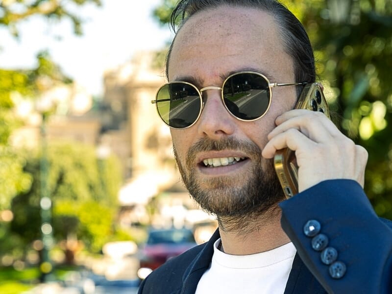 Homme barbu portant des lunettes rondes lors d'un shooting avec un photographe lifestyle à la colline du château de Nice