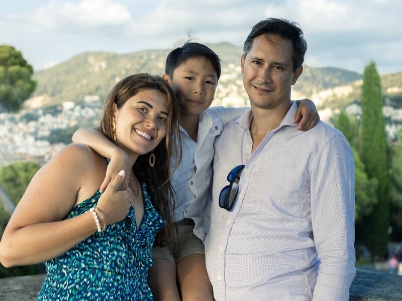 Trois personnes souriantes en extérieur lors d'un shooting photo famille à la colline du chpateau de Nice