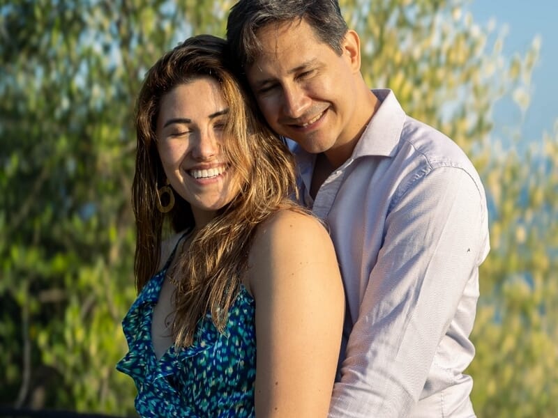 Un couple souriant s'enlaçant lors d'une shooting avec un photographe de couple à la colline du château de Nice