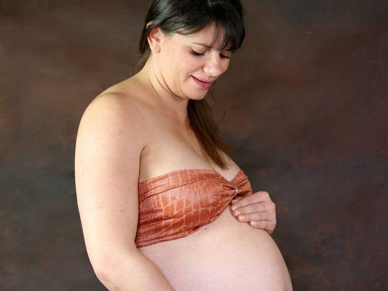 Future maman en tissu satiné orange, image prise lors d'un shooting photo grossesse à Dijon