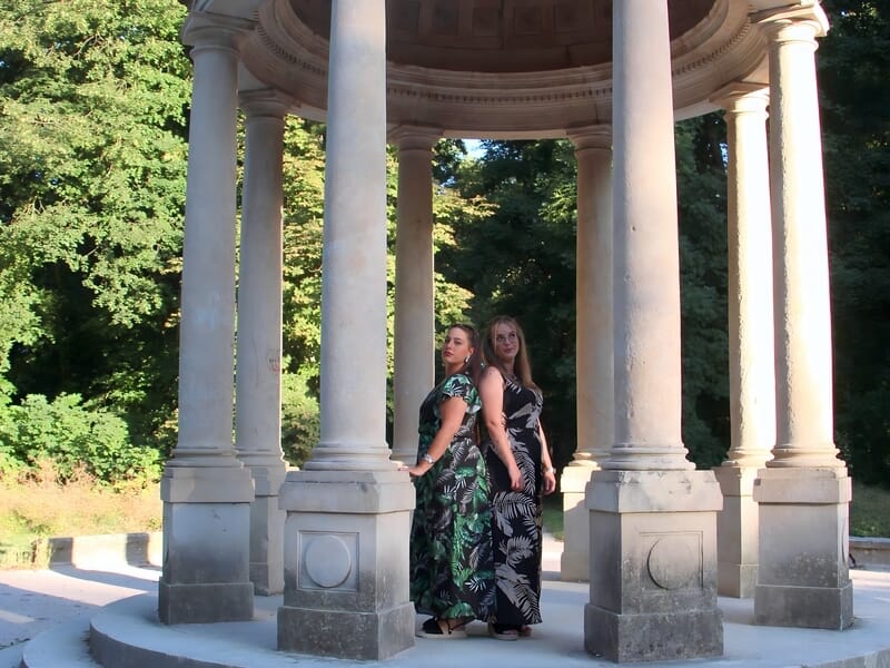 Séance photo portrait Dijon, deux femmes élégantes en robes longues posant sous un kiosque à colonnes en pierre.