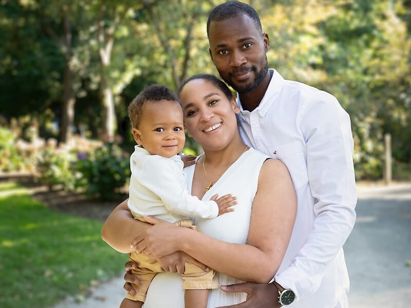 Un couple avec un bébé dans un parc, tous souriants et proches, ambiance chaleureuse et familiale en extérieur lors d'un shooting photo famille à Angers.