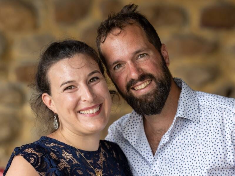 Un jeune couple prend la pose avec un grand sourire.