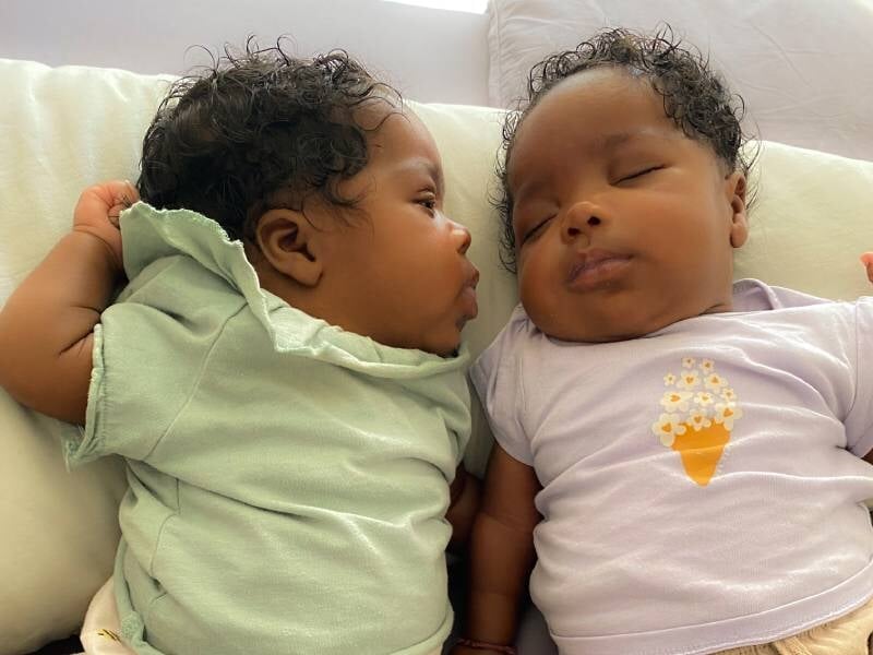 Deux bébés endormis sont allongés côte à côte.