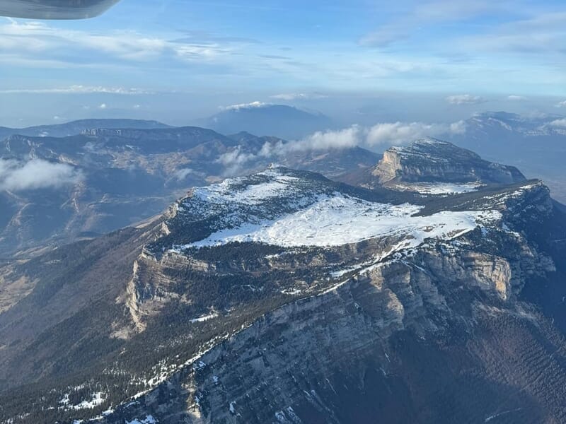 Pilotage avion ULM Lac du Bourget avec survol d’une montagne enneigée et panorama alpin.