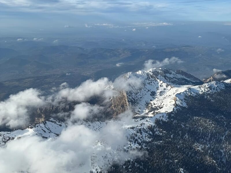 Pilotage avion ULM Lac du Bourget offrant une vue aérienne sur les crêtes enneigées et la vallée.