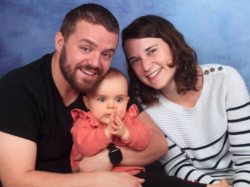 Deux parents prennent la pose avec leur bébé.