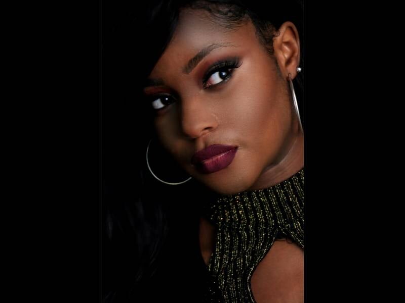Une femme de couleur avec un beau maquillage prend la pose.