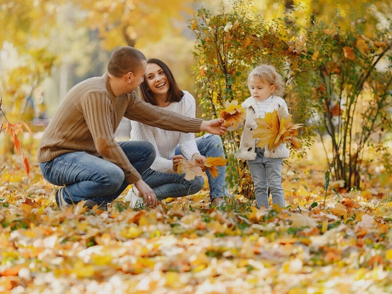 Un couple souriant joue avec leur petite fille lors d'un shooting photo famille à Amiens.
