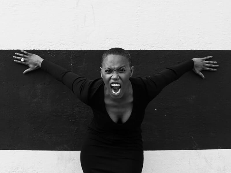 Femme en robe noire criant avec intensité lors d'un shooting photo lifestyle à Amiens.