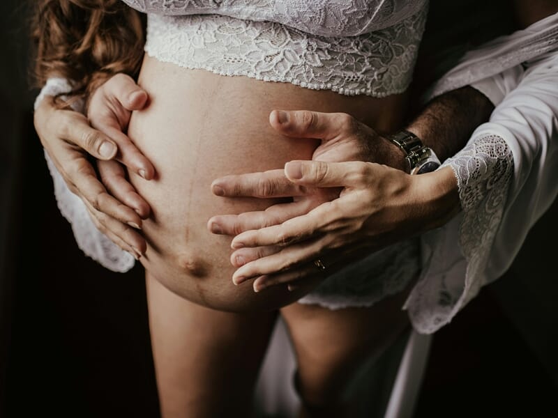 Ventre de femme enceinte lors d'un shooting avec un photographe de grossesse près de Strasbourg.