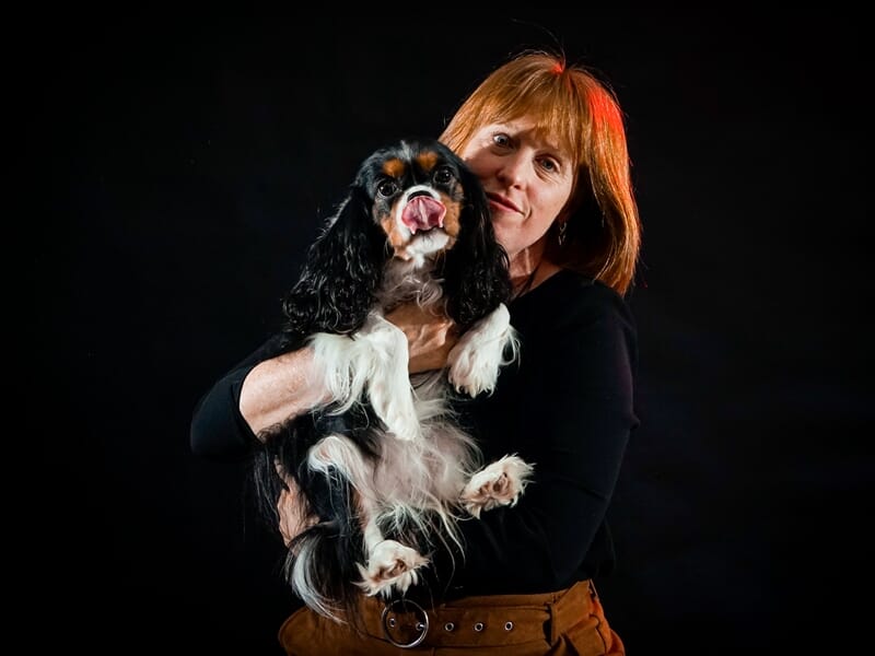 Femme rousse tenant un chien noir, blanc et marron, lors d'un shooting photo animal de compagnie près de Strasbourg.