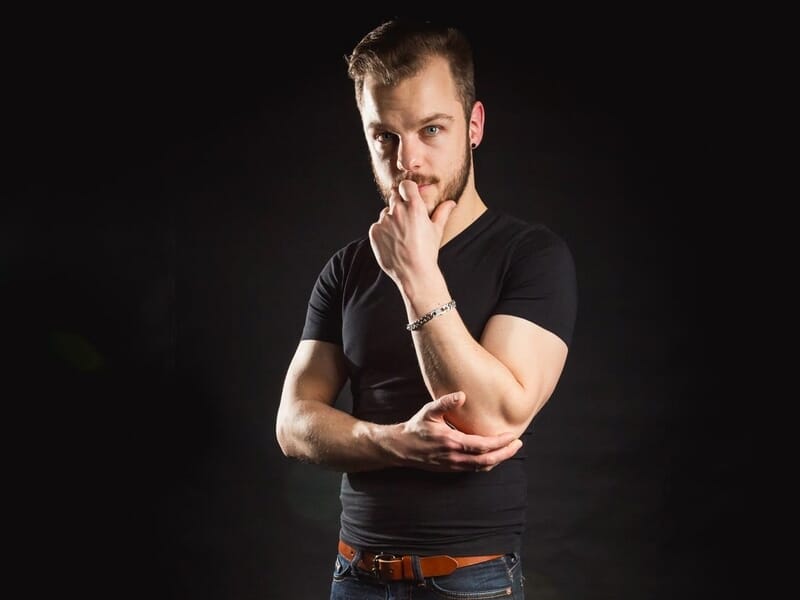 Jeune homme barbu en t-shirt noir lors d'un shooting avec un photographe de portrait près de Strasbourg.
