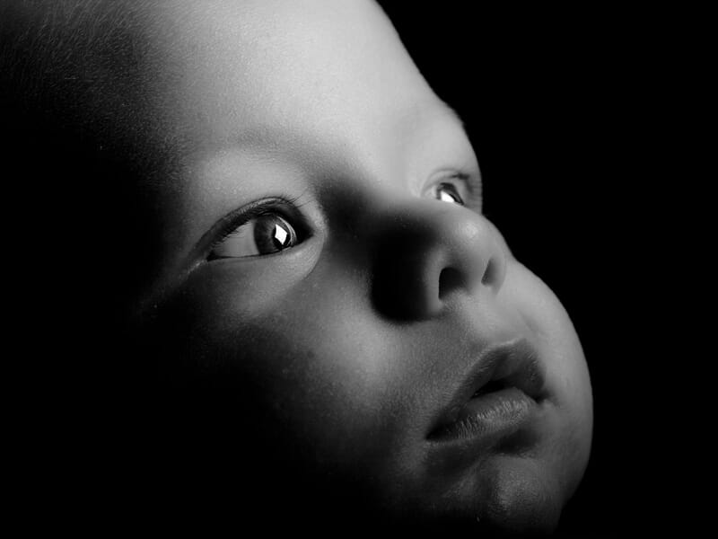 Portrait en noir et blanc d'un bébé regardant vers le haut lors d'un shooting photo bébé près de Strasbourg.
