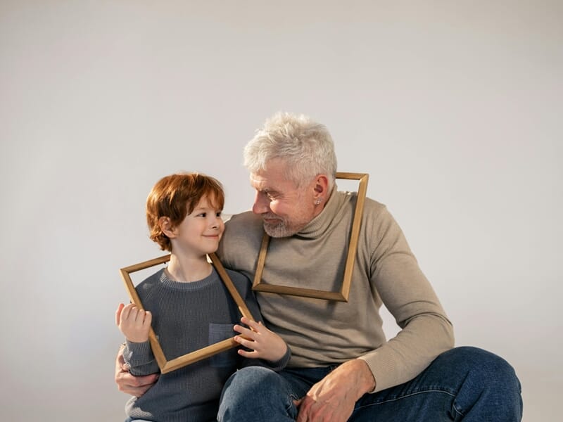 Un grand-père et son petit-fils souriants lors d'un shooting avec un photographe famille.