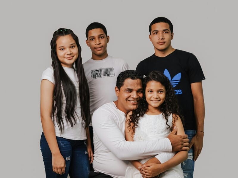 Un père entouré de ses quatre enfants lors d'un shooting avec un photographe famille.
