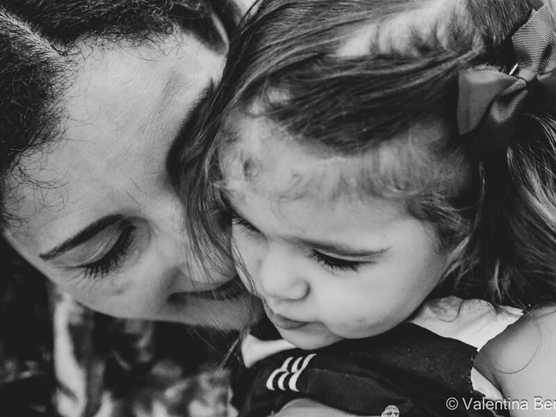 Photo en noir et blanc d'une femme embrassant tendrement une petite fille lors d'un shooting photo famille à Béziers.