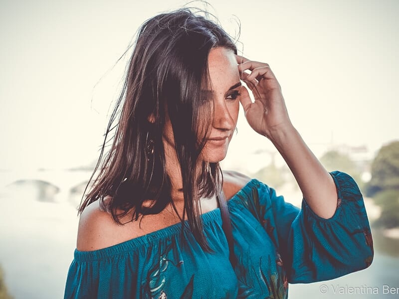 Femme aux cheveux longs et robe bleue lors d'un shooting photo portrait à Béziers.