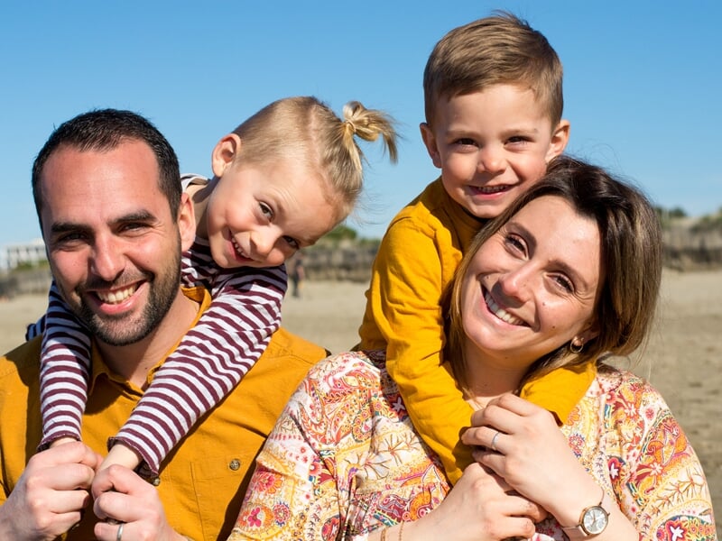 Couple avec deux jeunes enfants, tous souriants lors d'un shooting photo de famille à Nîmes.
