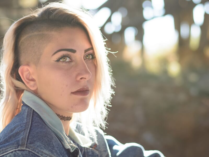 Jeune femme aux cheveux blonds rasés sur le côté, lors d'un shooting photo portrait à Nîmes.