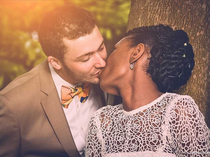 Couple d'amoureux s'embrassant tendrement devant un arbre lors d'un shooting photo grossesse au Mans.
