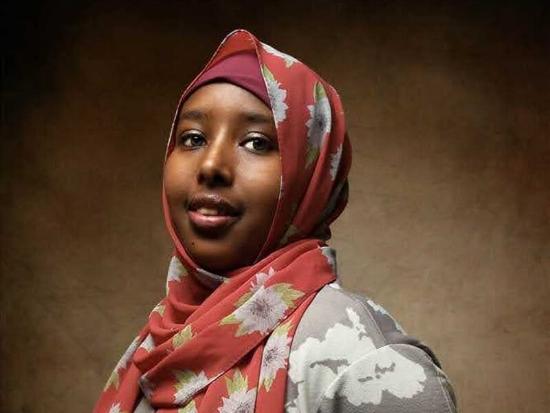 Portrait d'une femme souriante portant un foulard rouge à motifs lors d'un shooting photo portrait au Mans.