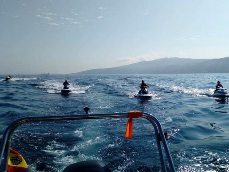 Jet ski rouge sur un lac avec un ciel bleu et des collines en arrière-plan