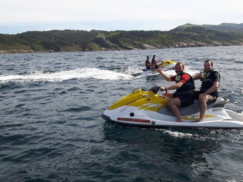 Personne en jet ski sur un lac avec un ciel clair et des collines en arrière-plan