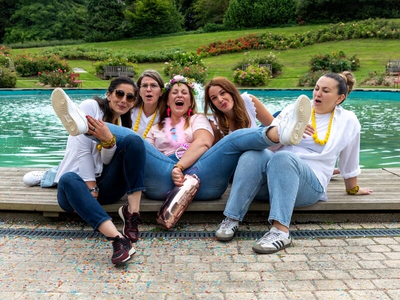 Cinq femmes assises près d'un bassin, riant lors d'un shooting photo lifestyle à Caen.