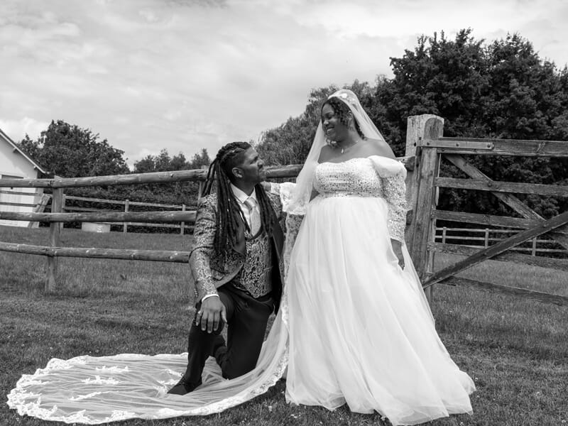Couple de mariés noirs en tenue élégante, la mariée en robe blanche avec voile lors d'un shooting photo à Caen.
