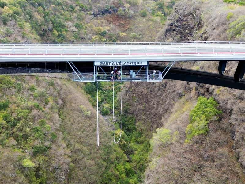 Vue d'un pont avec une plateforme de saut à l'élastique suspendue au-dessus d'une gorge rocheuse.