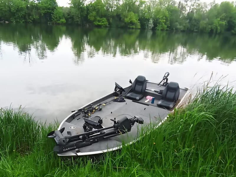 Petit bateau de pêche motorisé amarré au bord d'une rivière calme lors d'un stage de pêche près de Dijon.