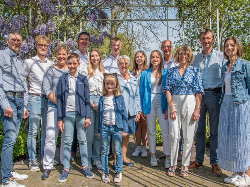 Groupe de personnes souriantes posant ensemble en extérieur lors d'un shooting photo famille à Dunkerque.