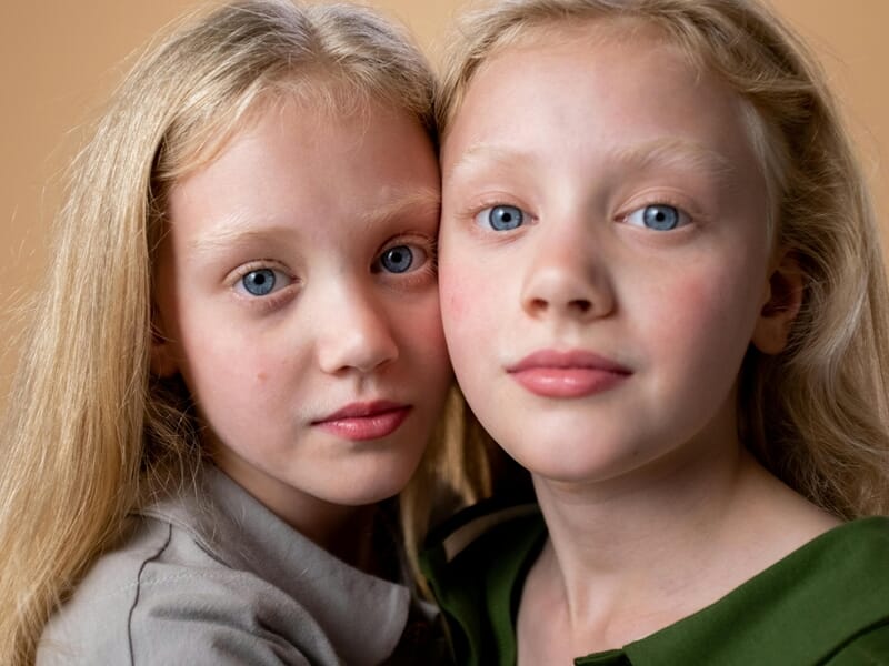 Portrait rapproché de deux jeunes filles blondes aux yeux bleus, lors d'un shooting photo de famille près de Nancy.