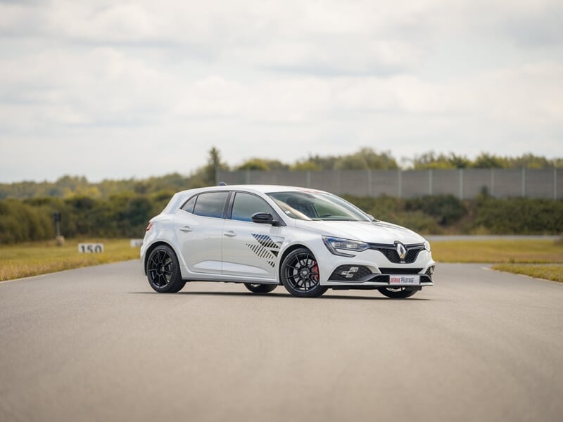 Voiture compacte blanche Renault Clio RS sur piste lors d'un coaching pilotage sur circuit.