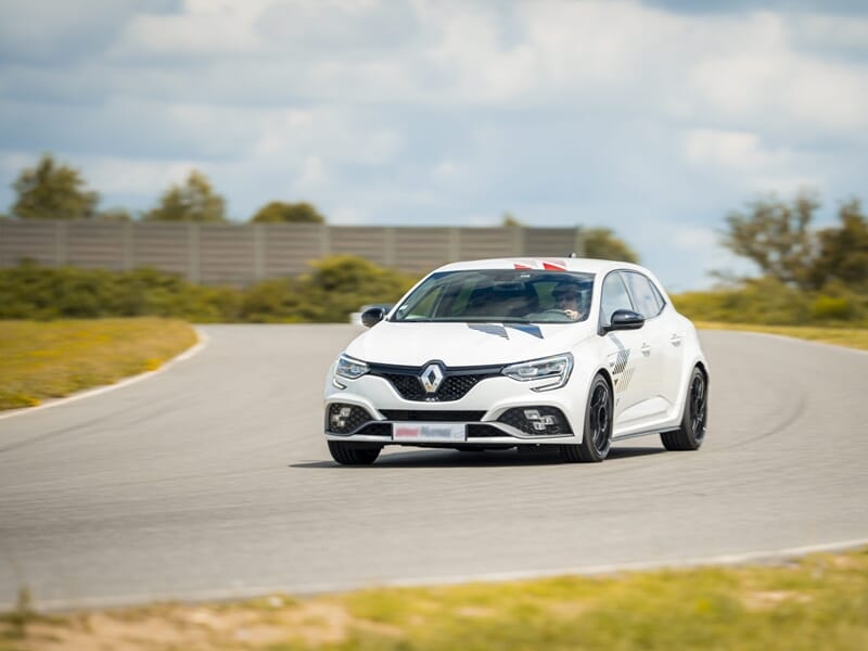 Voiture blanche Renault en pleine prise de virage lors d'un coaching pilotage sur le circuit Le Mans-Bugatti.
