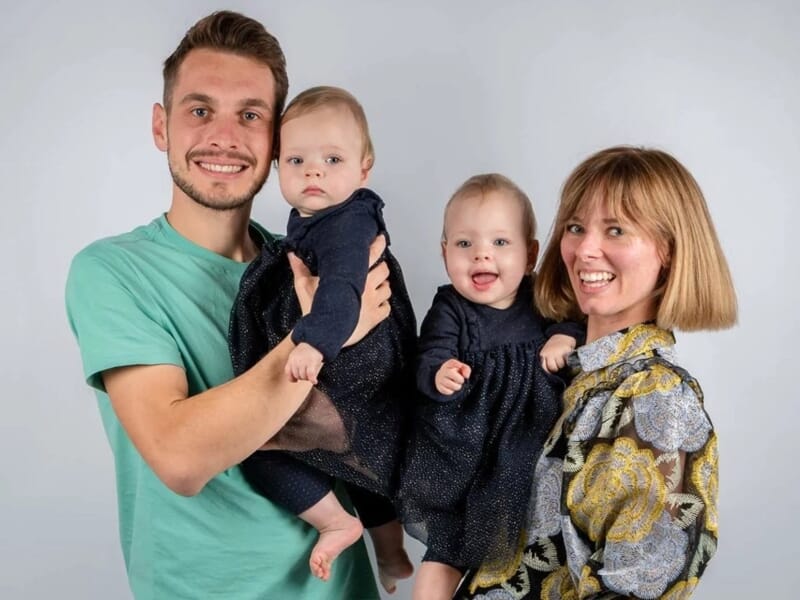 Un couple souriant tient dans ses bras deux bébés lors d'un shooting photo famille à Besançon.
