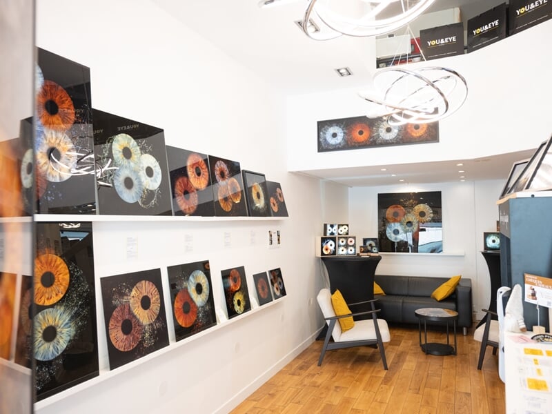 Intérieur d'une galerie d'art moderne avec des photos d'iris d'yeux accrochées aux murs blancs.