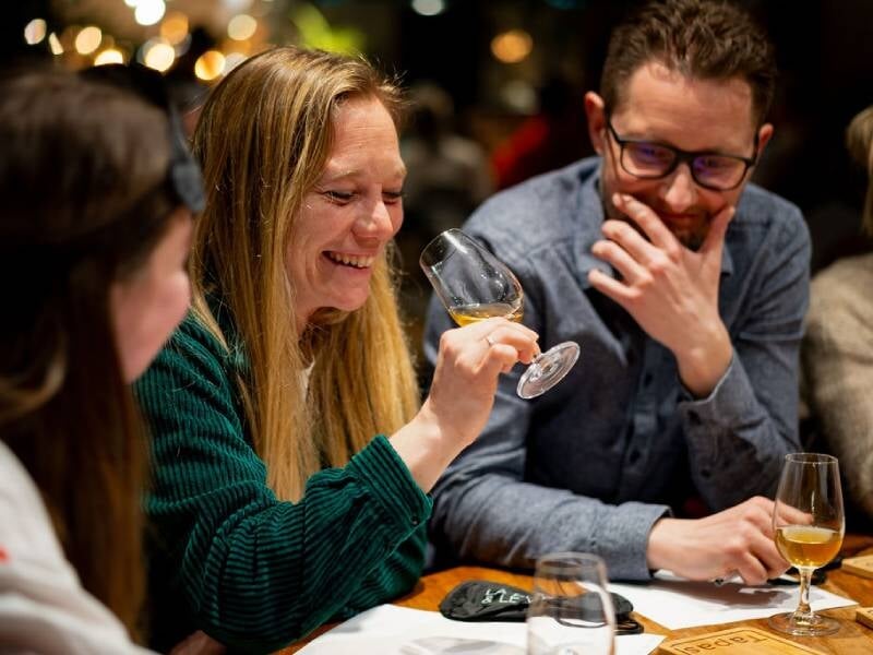 Des amis dégustent du vin dans une ambiance conviviale et chaleureuse lors d'une dégustation de vin à Lille.