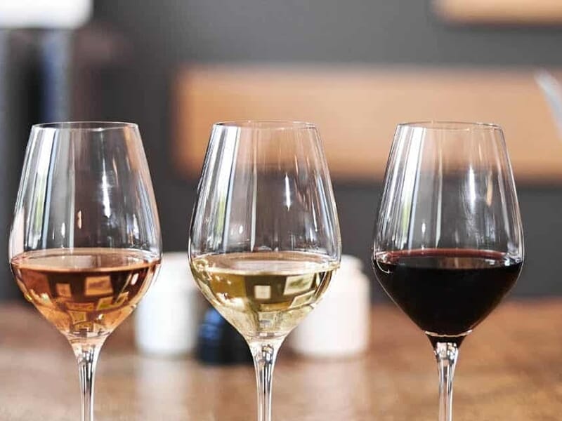 Trois verres de vin alignés sur une table, contenant du vin rosé, blanc et rouge, lors d'un cours d'oenologie près de Cholet.