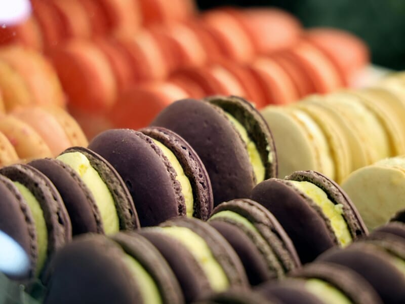 Gros plan sur une rangée de macarons colorés alignés, avec des teintes variées et une texture délicate.