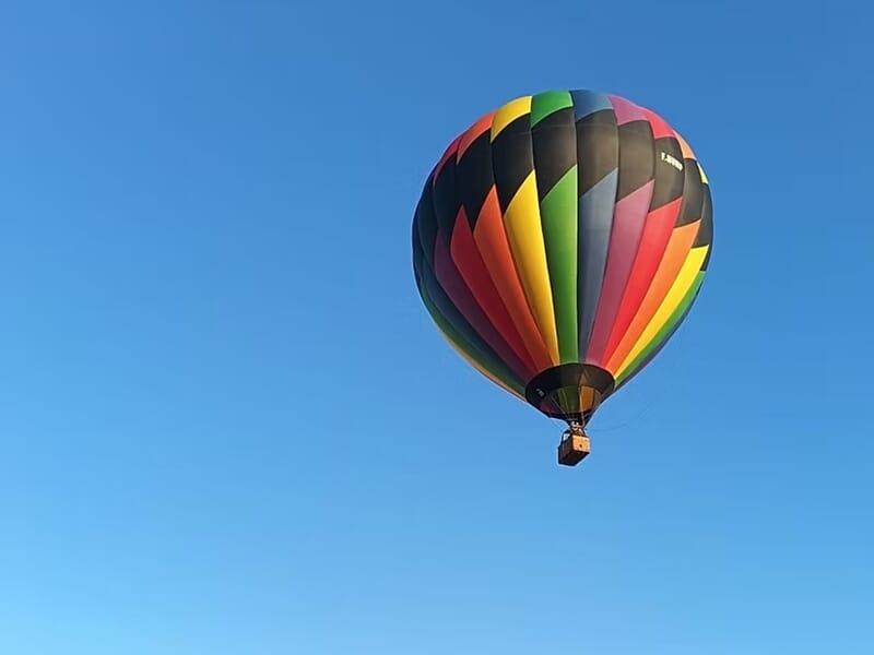 Montgolfière aux couleurs vives flottant dans un ciel bleu dégagé sans nuages