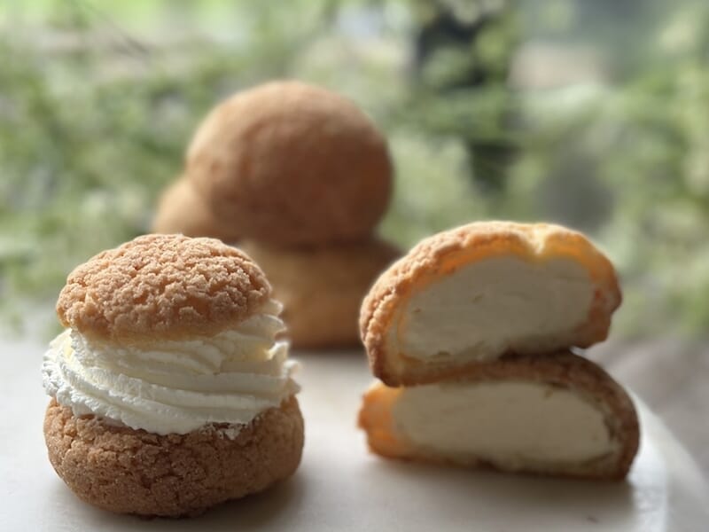Deux choux à la crème, l'un entier et l'autre coupé en deux, lors d'un cours de pâtisserie à Lille.