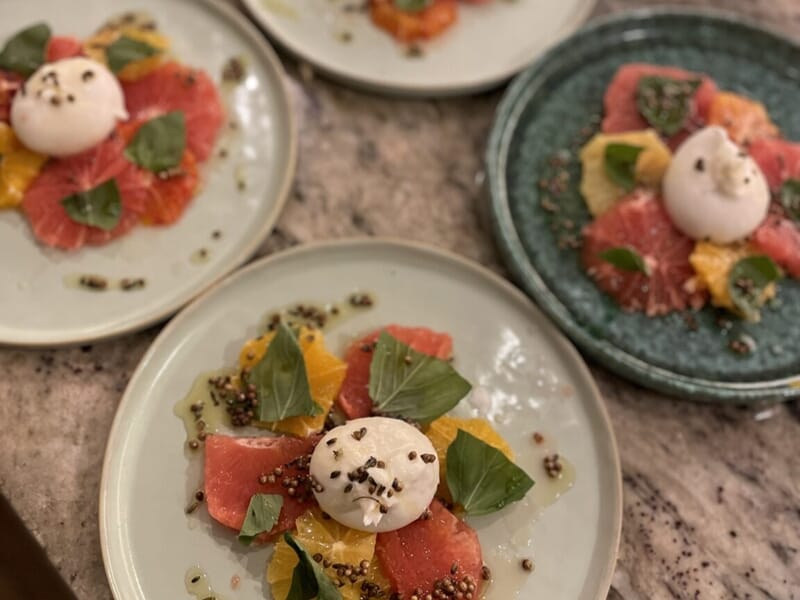 Assiettes avec salade colorée composée de tranches d'agrumes, lors d'un cours de cuisine à Lille.