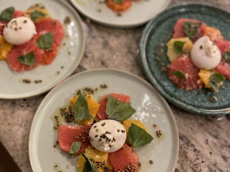 Assiettes avec salade colorée composée de tranches d'agrumes, lors d'un cours de cuisine à Lille.