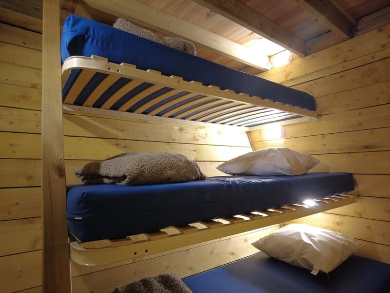 Lits superposés avec matelas bleus et oreillers dans une petite chambre lors d'une nuit cabane près de Saint-Nazaire.