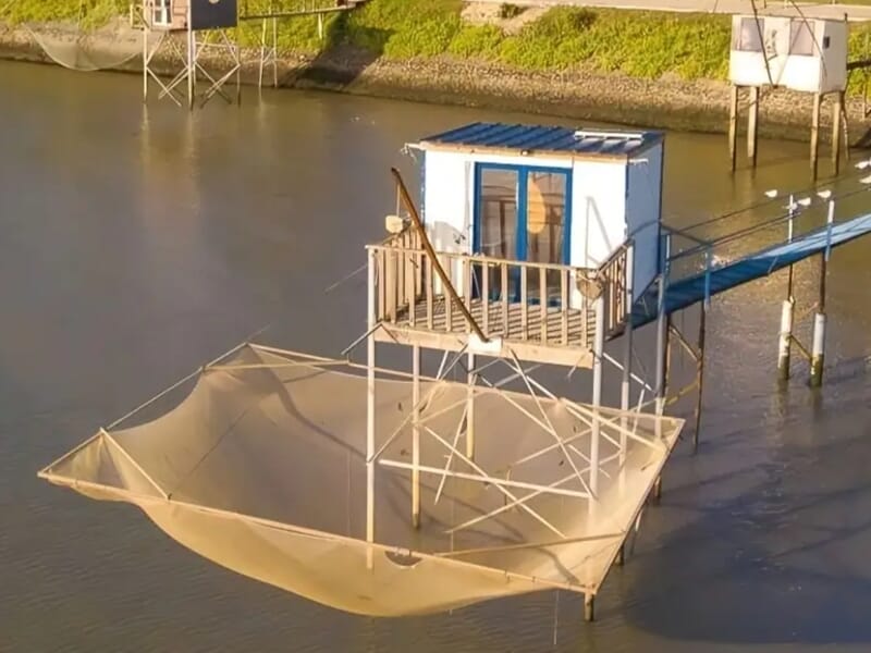 Cabane de pêche sur pilotis avec filet carré déployé dans une rivière calme, lors d'une location pêche à Saint-Nazaire.