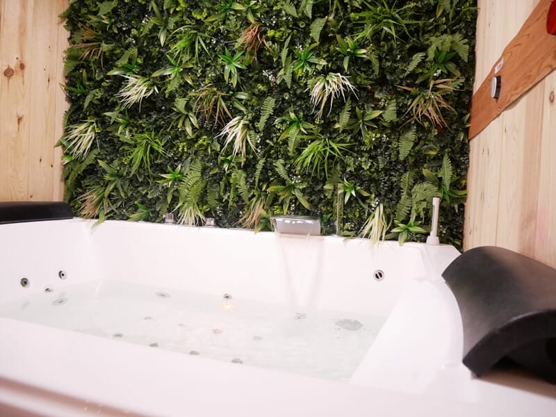 Baignoire jacuzzi blanche avec eau en mouvement, lors d'une nuit en Love Room près de Bourges.