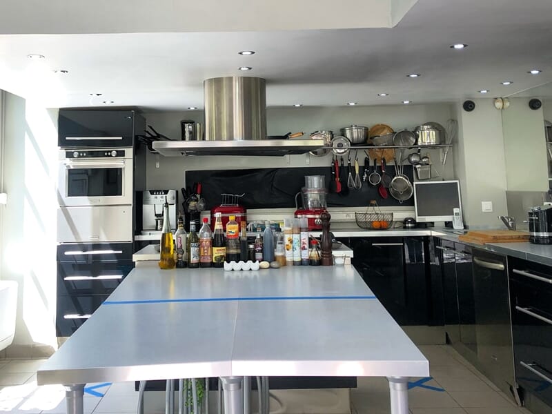 Cuisine moderne équipée avec plan de travail, condiments et ustensiles prêts pour un cours de cuisine à Nice.