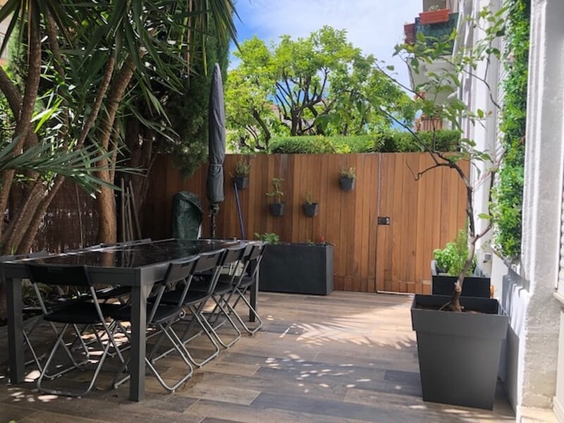 Terrasse extérieure avec table et chaises lors d'un cours de cuisine à Nice. 